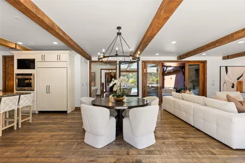 a dining room with wooden floor and chandelier