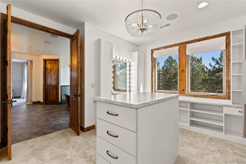 a view of a hardwood & hallway with a chandelier