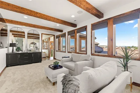 a living room with furniture fireplace and large windows