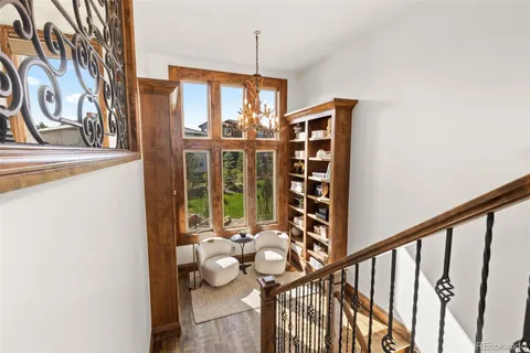 a view of a hallway with wooden floor and staircase