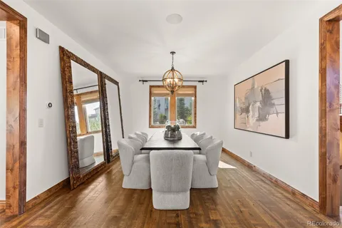 a dining room with furniture wooden floor a rug and a painting