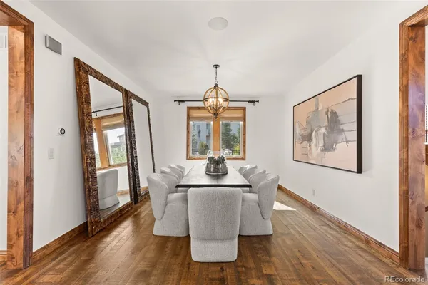 a dining room with furniture wooden floor a rug and a painting