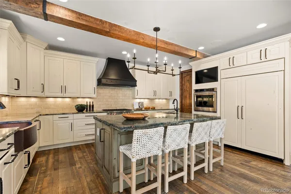 a kitchen with granite countertop a sink stove and refrigerator