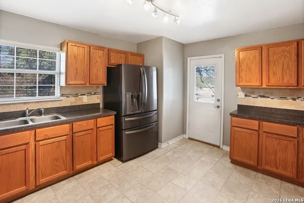 a kitchen with stainless steel appliances granite countertop a refrigerator and a sink