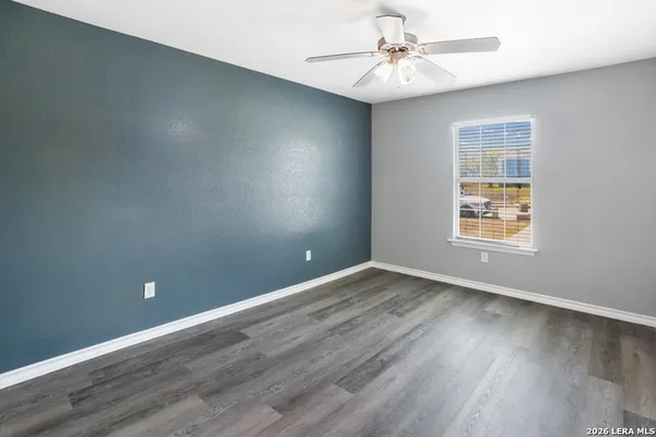 a view of an empty room with window and wooden floor