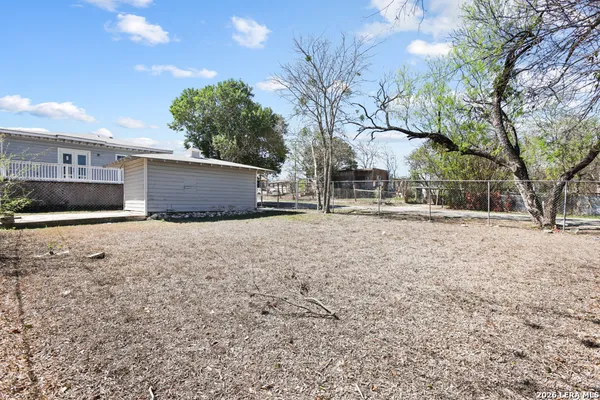 a backyard of a house with a large tree