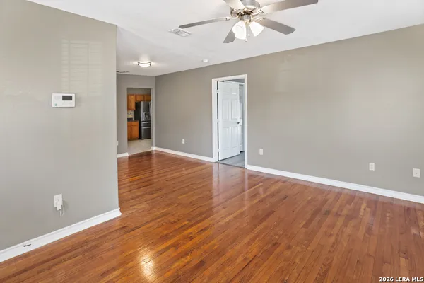 a view of an empty room with wooden floor