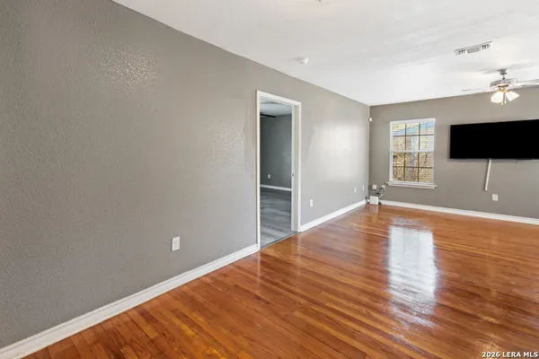 a view of a livingroom with wooden floor and a flat screen tv