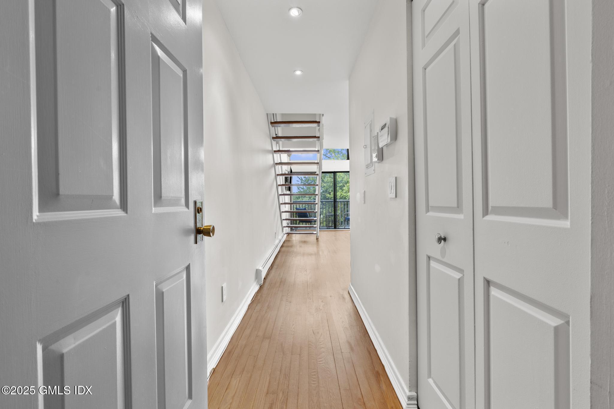 1465 East Putnam Avenue, Unit 421 Riverside, CT 06878 - Photo 2 of 29 a view of a hallway with wooden floor and staircase