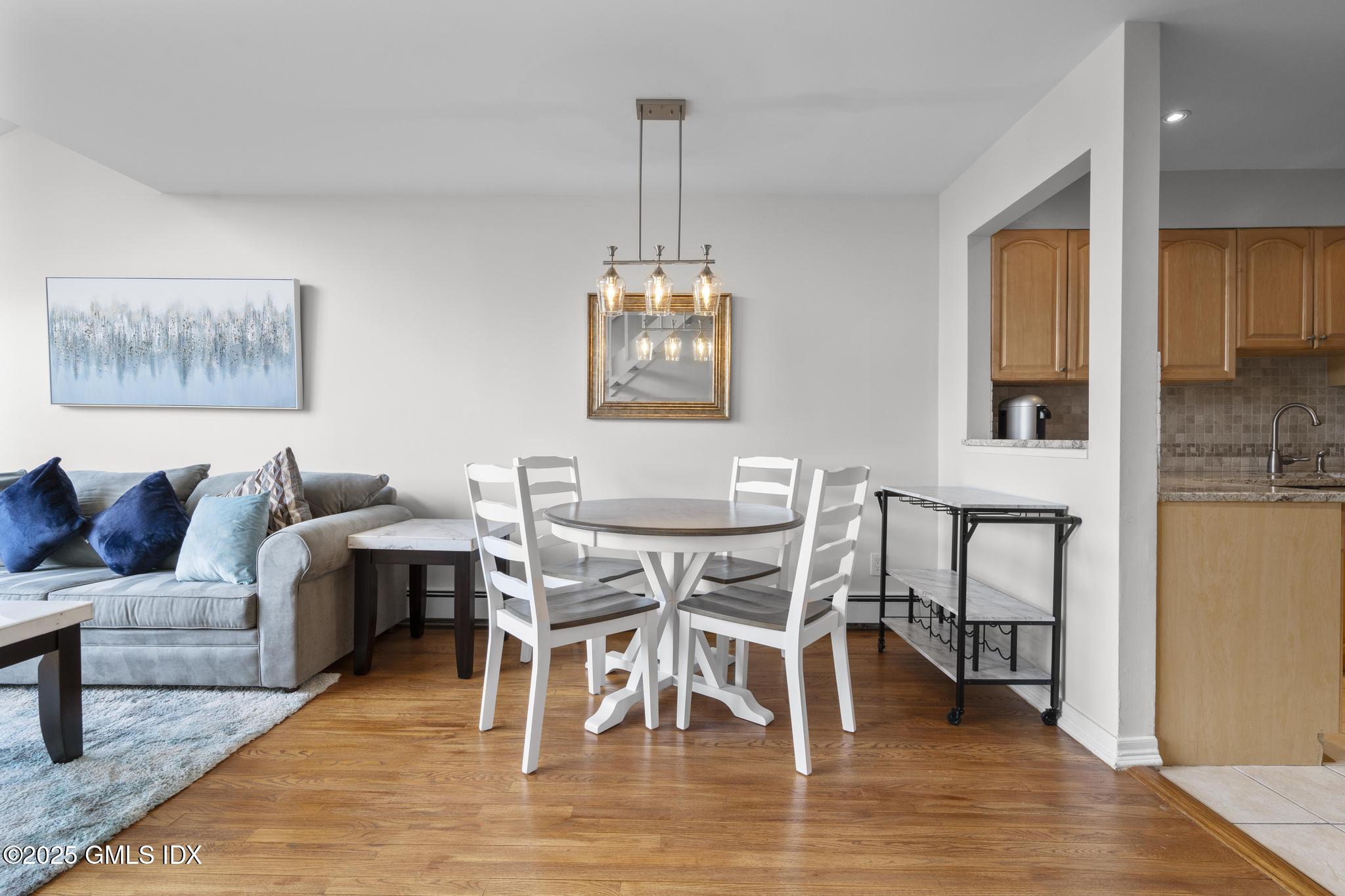 1465 East Putnam Avenue, Unit 421 Riverside, CT 06878 - Photo 5 of 29 a view of a dining room with furniture window and wooden floor