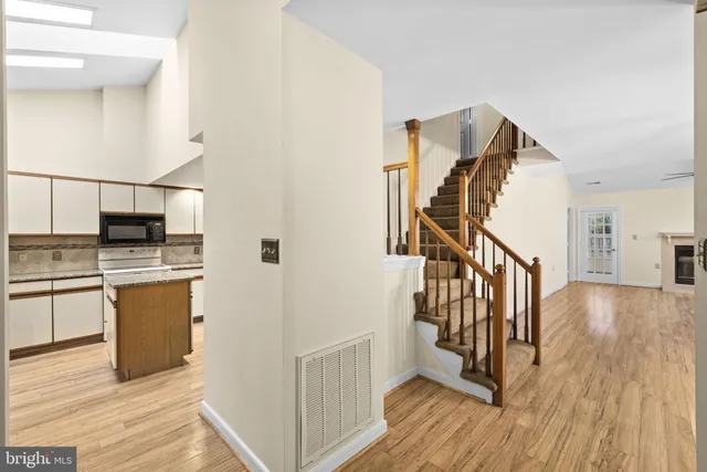 a view of a hallway with wooden floor and staircase