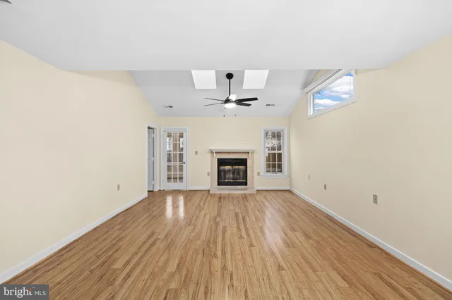 an empty room with windows and fireplace