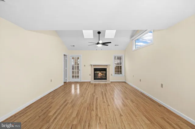 an empty room with windows and fireplace