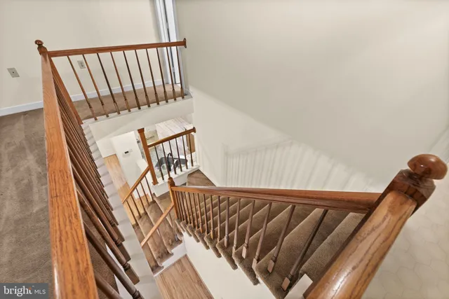 a view of staircase with wooden floor and white walls