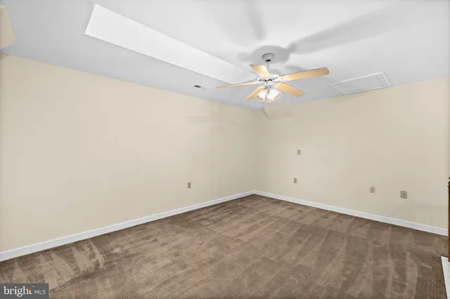 an empty room with a window and a ceiling fan