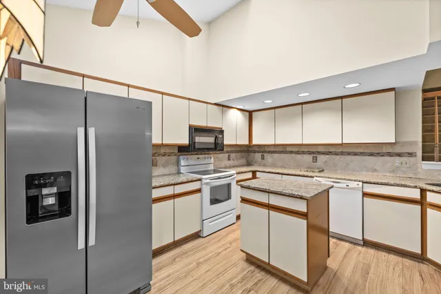 a kitchen with a sink a refrigerator and cabinets