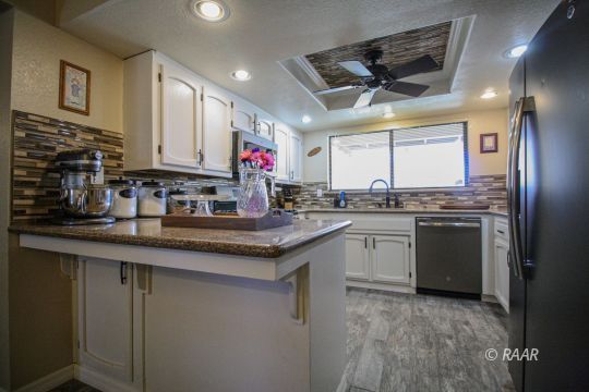 1124 Faith Court Ridgecrest, CA 93555 - Photo 8 of 35 a kitchen with granite countertop a sink stainless steel appliances and cabinets