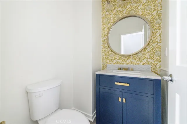 a view of empty room with wooden floor and kitchen