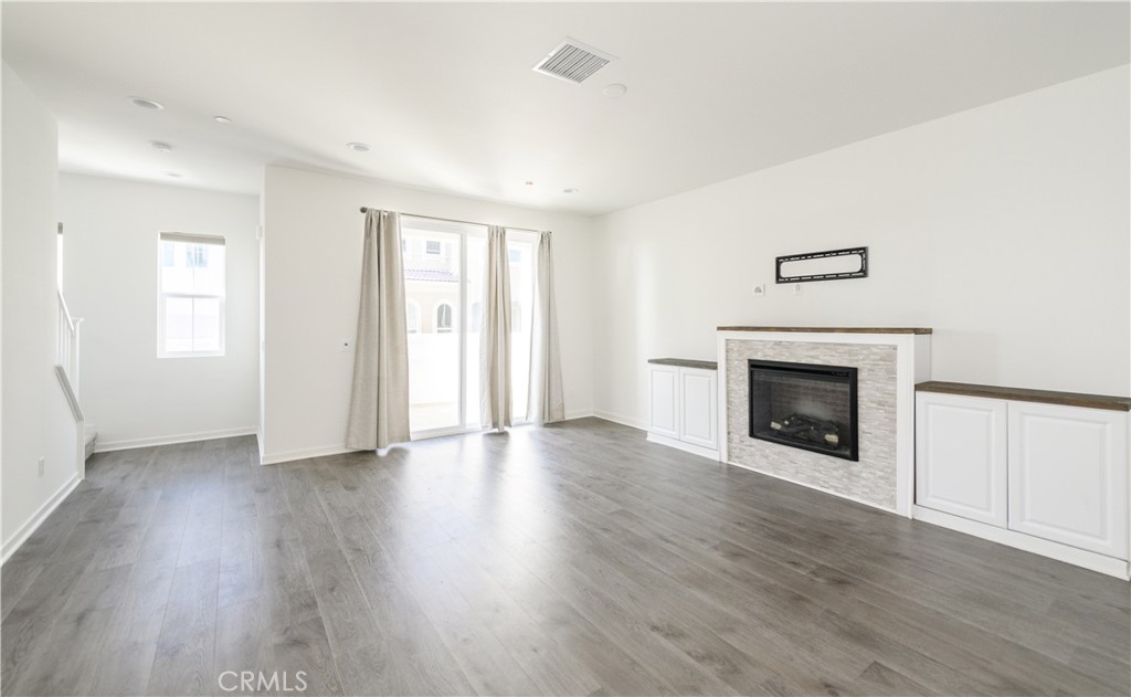 603 Shadowbrook Lake Forest, CA 92610 - Photo 15 of 60 an empty room with wooden floor fireplace and windows