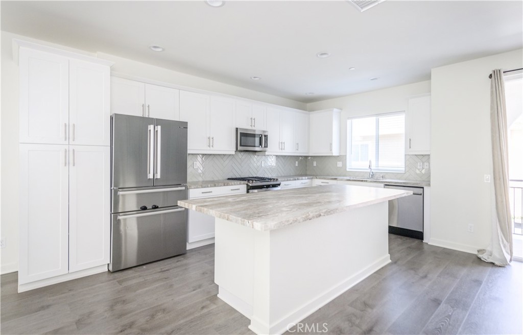 603 Shadowbrook Lake Forest, CA 92610 - Photo 17 of 60 a kitchen with a refrigerator stove and wooden cabinets