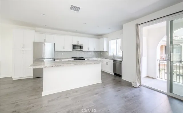 a kitchen with granite countertop white cabinets and white appliances