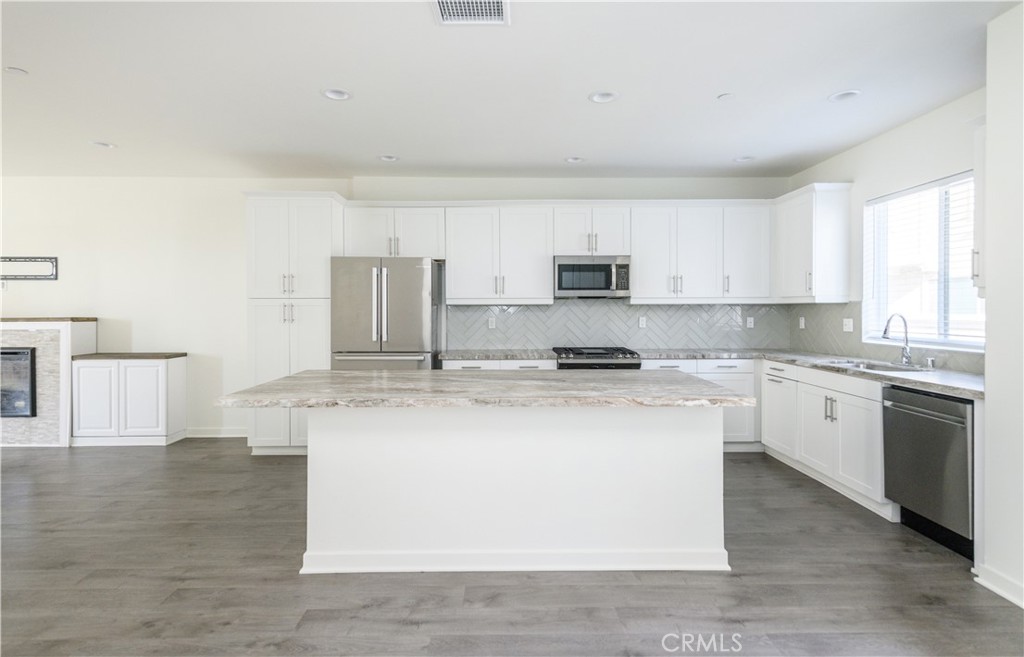 603 Shadowbrook Lake Forest, CA 92610 - Photo 19 of 60 a kitchen with stainless steel appliances granite countertop a stove a sink a refrigerator a microwave and white cabinets
