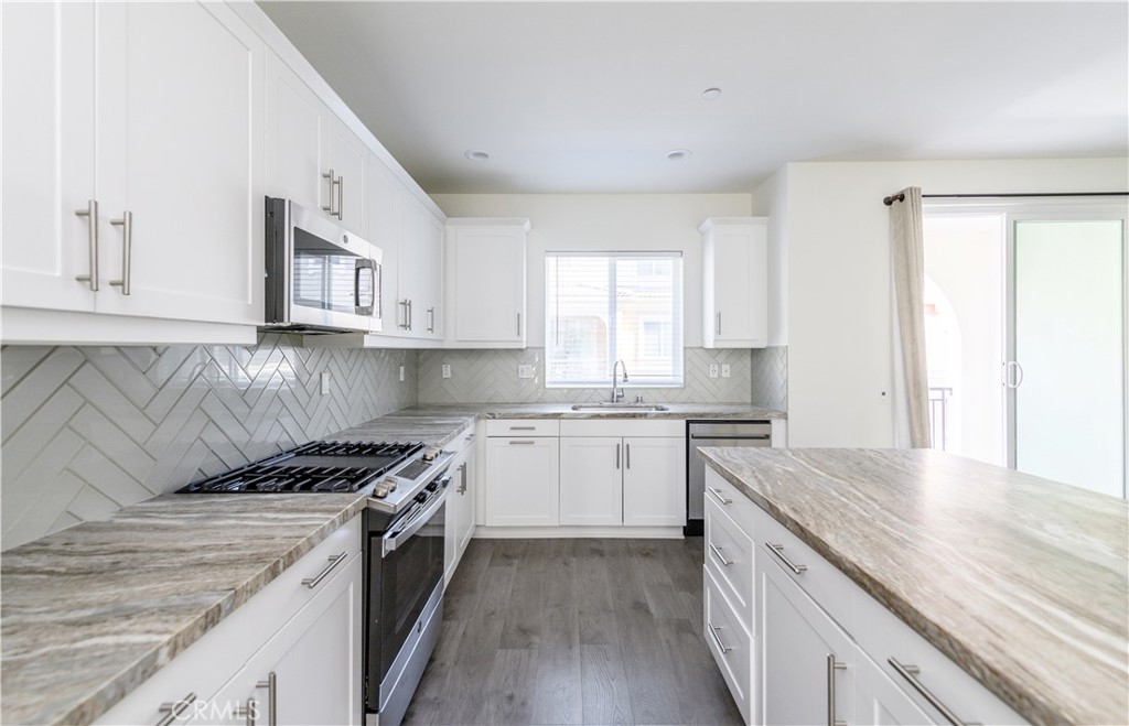 603 Shadowbrook Lake Forest, CA 92610 - Photo 24 of 60 a kitchen with a sink stove top oven and cabinets