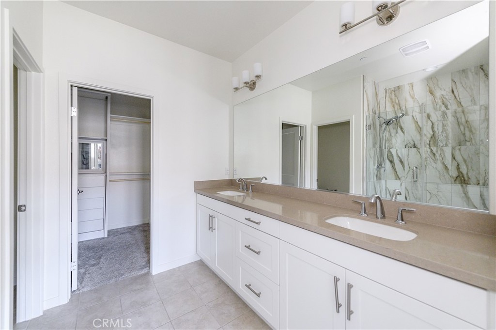 603 Shadowbrook Lake Forest, CA 92610 - Photo 33 of 60 a bathroom with a granite countertop sink a mirror and a shower