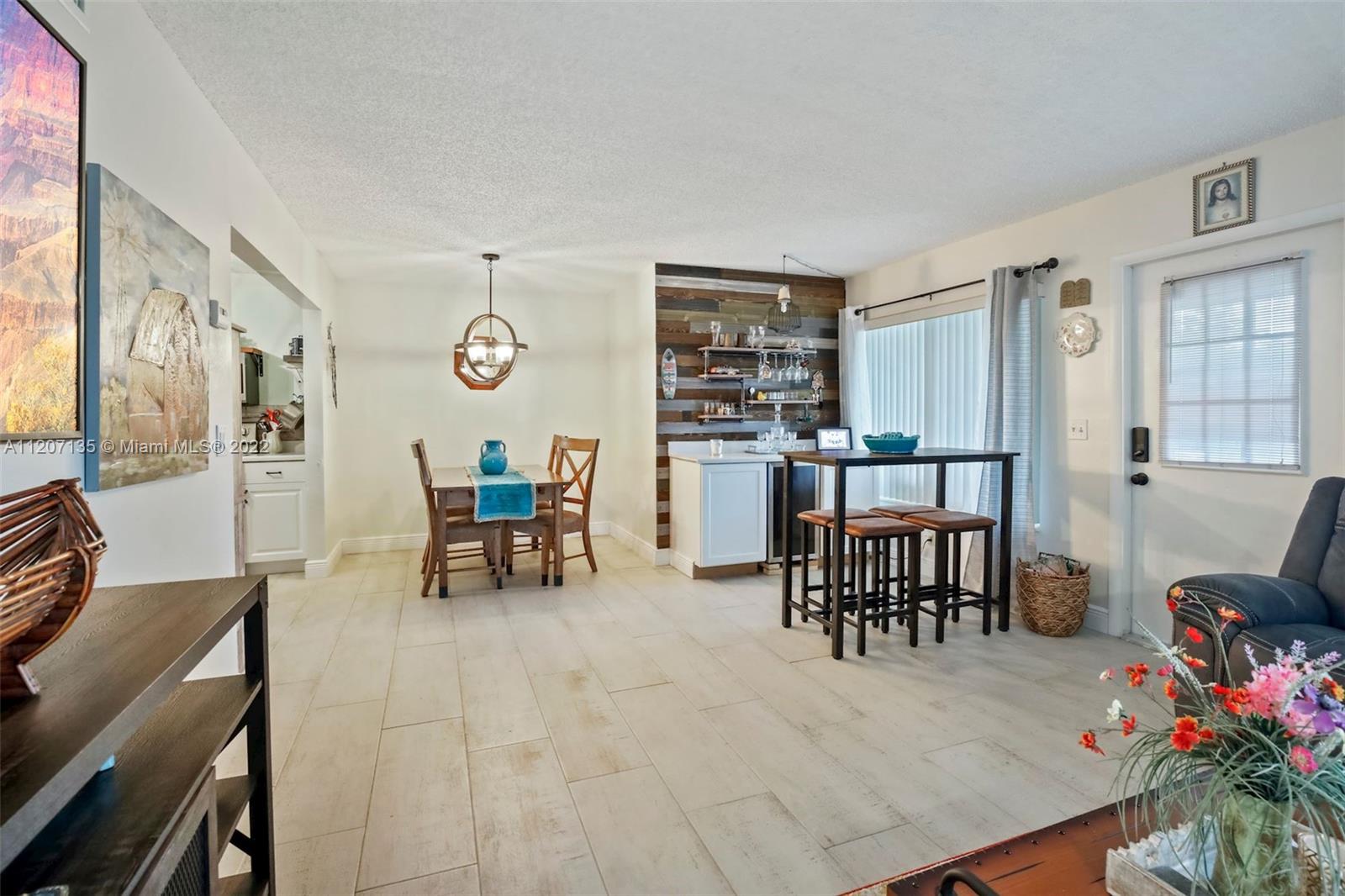 334 Pine Ridge Circle, Unit A2 Greenacres, FL 33463 - Photo 6 of 16 a living room with furniture a dining table and chairs with wooden floor