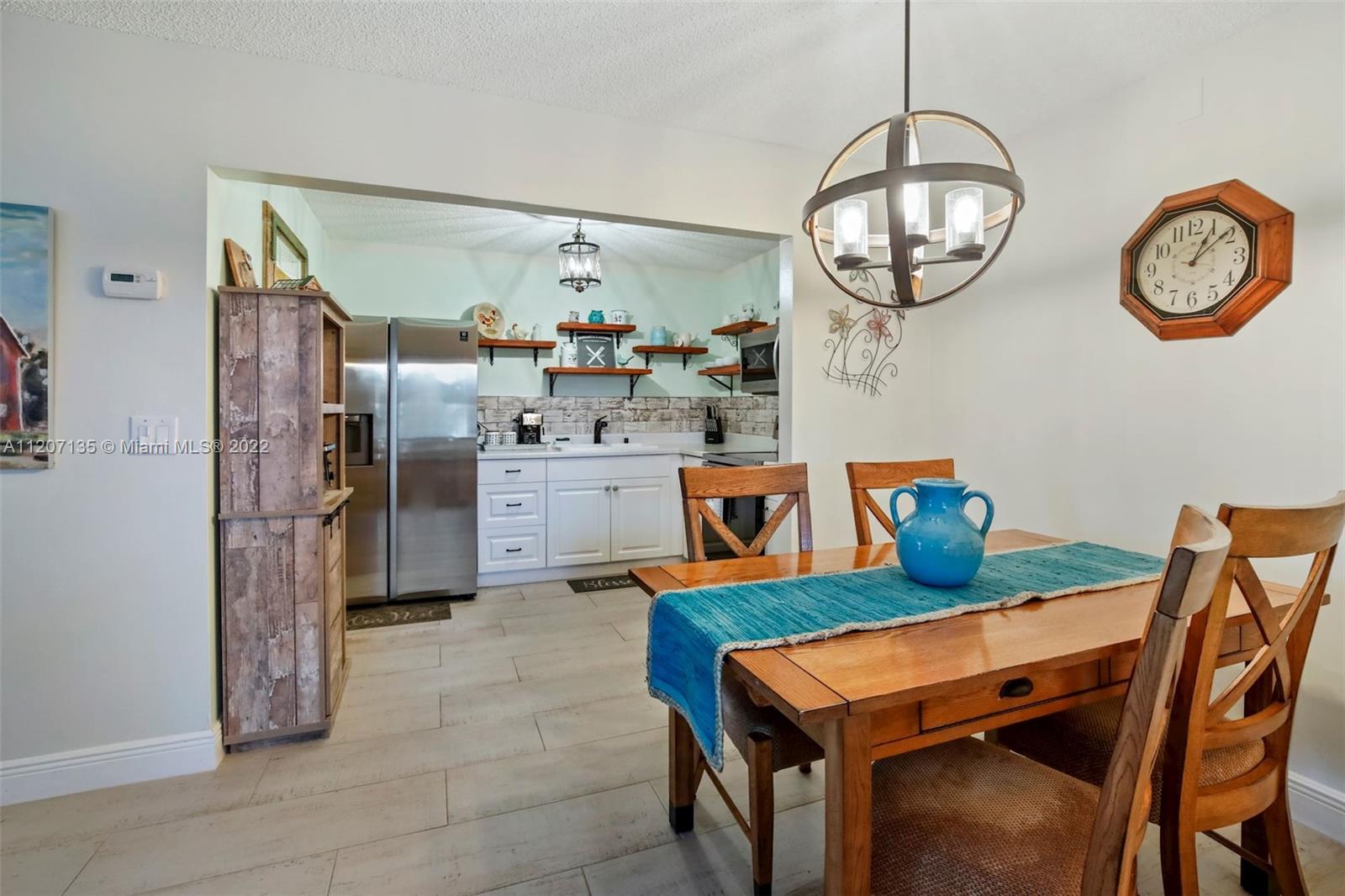 334 Pine Ridge Circle, Unit A2 Greenacres, FL 33463 - Photo 8 of 16 a room with stainless steel appliances kitchen island granite countertop furniture and a chandelier