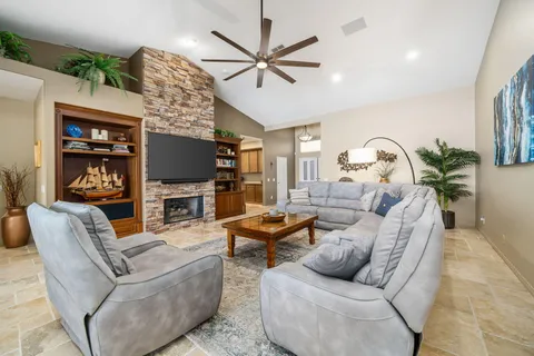 a living room with furniture a flat screen tv and a fireplace