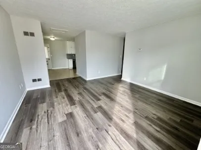 a view of a room with wooden floor and a sink