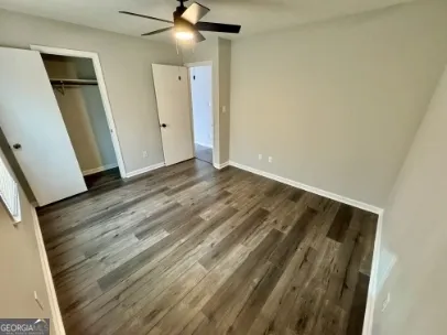 an empty room with wooden floor and entrance