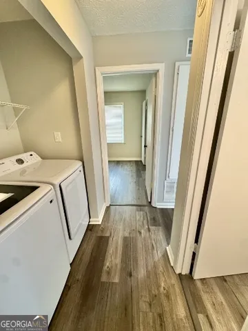 a view of washer and dryer with wooden floor