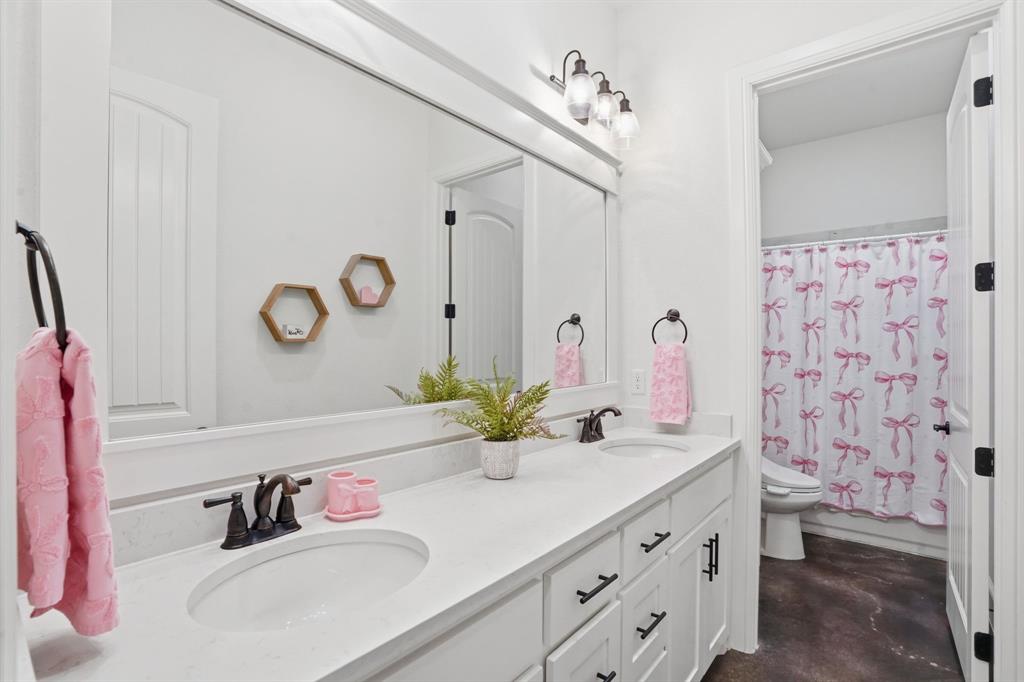 103 Apollo Trail Aurora, TX 76078 - Photo 9 of 40 Bathroom featuring double vanity, concrete flooring, and shower / bathtub combination with curtain