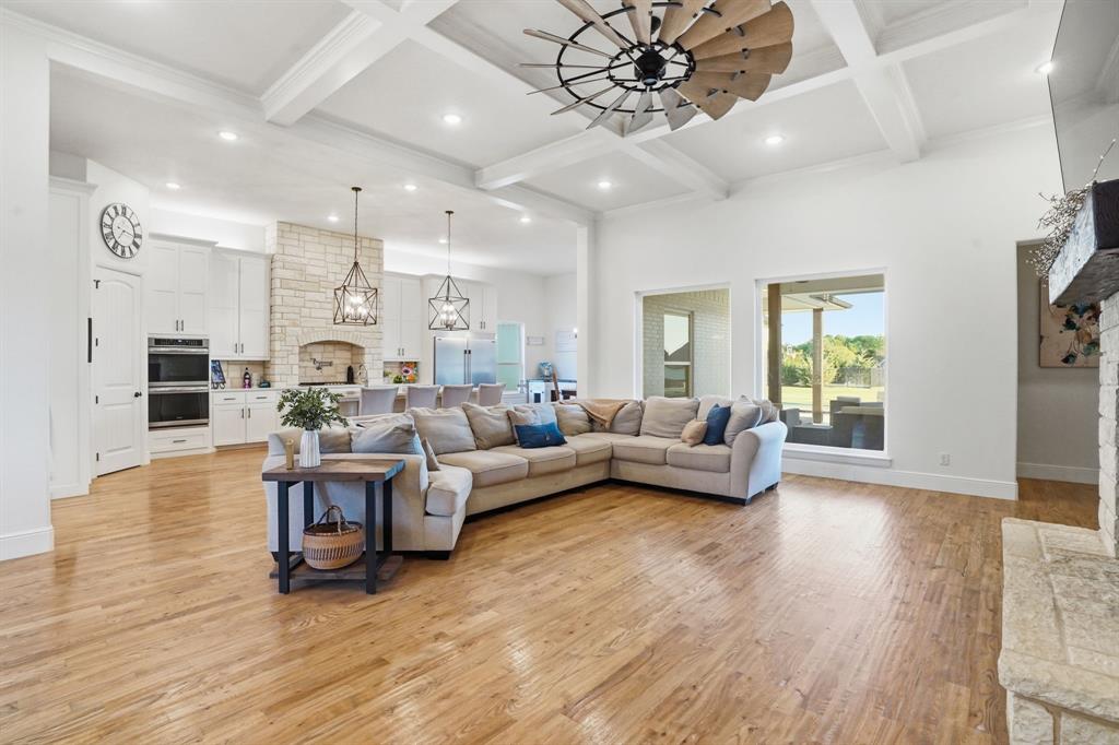 103 Apollo Trail Aurora, TX 76078 - Photo 10 of 40 Living room featuring light wood finished floors, a fireplace, coffered ceiling, a ceiling fan, and hanging lights