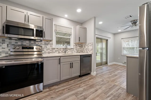 a kitchen with stainless steel appliances granite countertop a stove a sink and a microwave