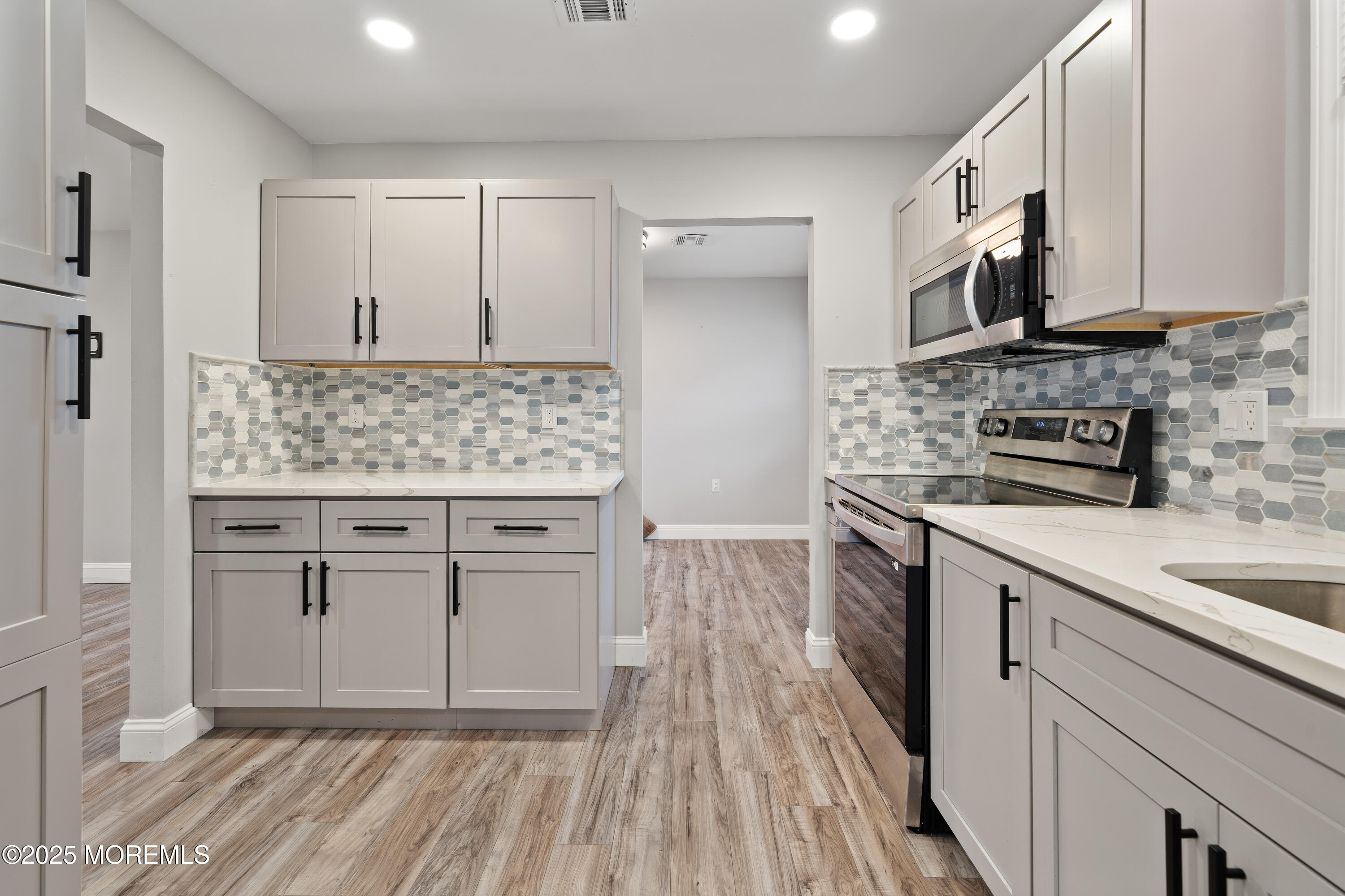 81 Falmouth Avenue, Unit 72 Whiting, NJ 08759 - Photo 8 of 20 a kitchen with stainless steel appliances granite countertop a stove a sink and a microwave