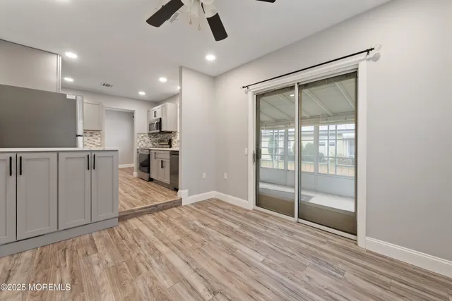 a view of empty room with wooden floor and window