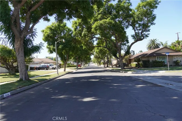 a view of street with houses and trees in the background