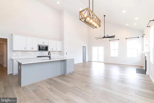 a large kitchen with cabinets wooden floor and stainless steel appliances