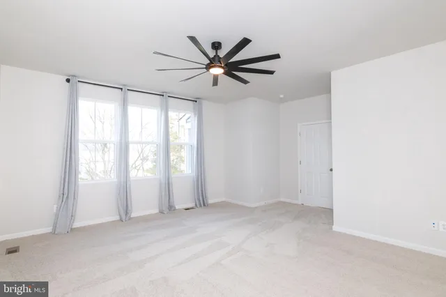 a view of a livingroom with a ceiling fan and window