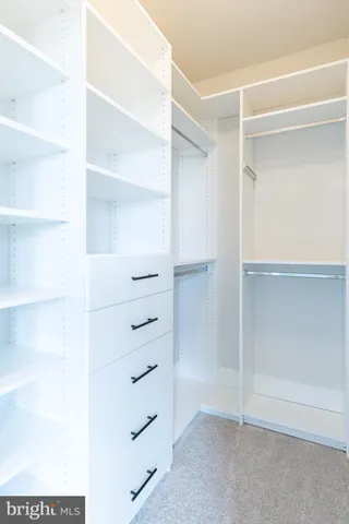 a view of walk in closet with empty racks