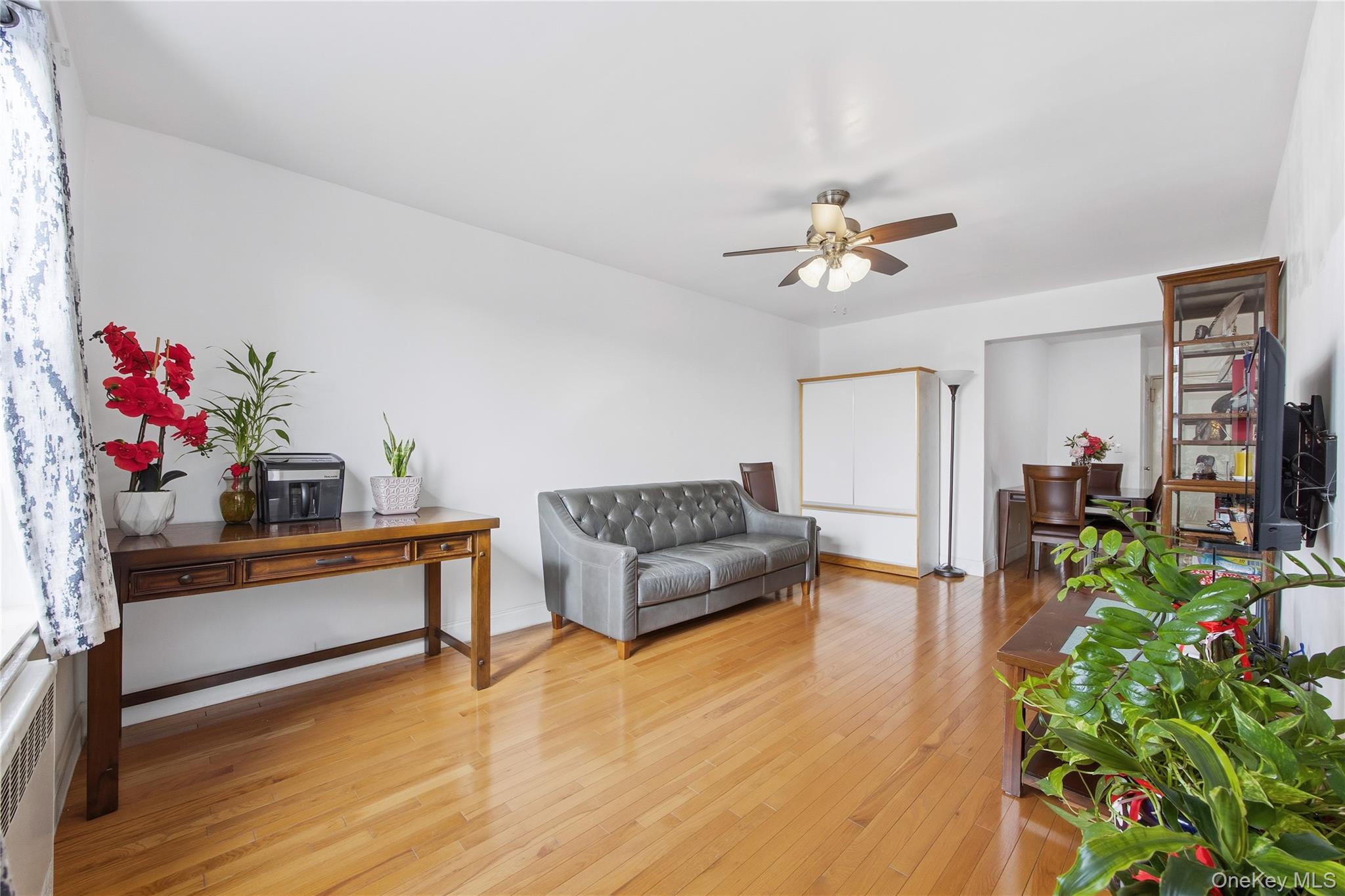150-25 72nd Road, Unit 6A Queens, NY 11367 - Photo 4 of 13 a living room with furniture and a chandelier