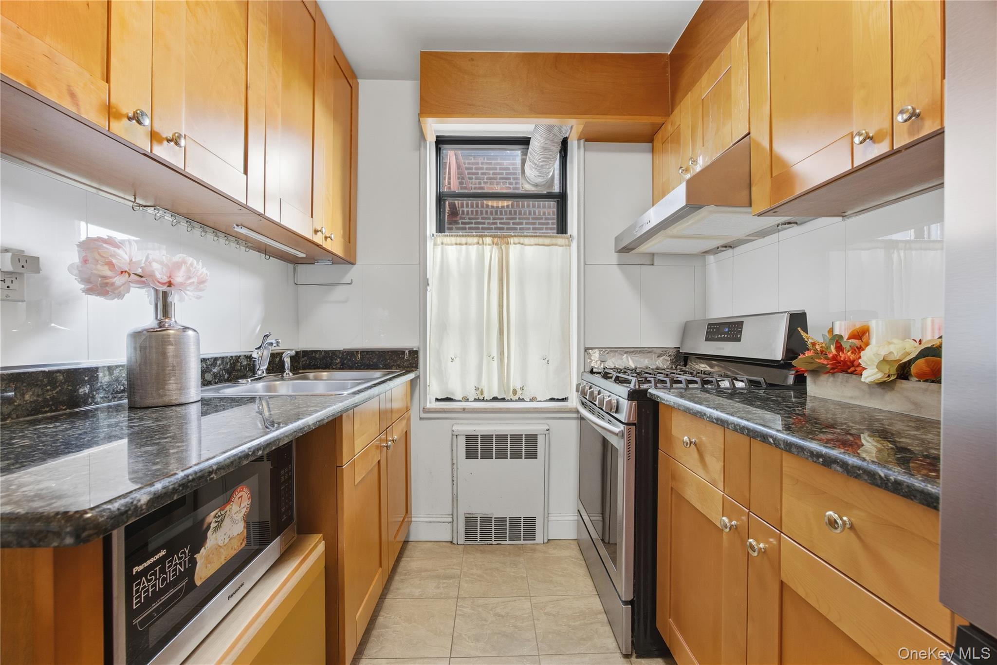 150-25 72nd Road, Unit 6A Queens, NY 11367 - Photo 5 of 13 a kitchen with stainless steel appliances granite countertop a stove a sink and a microwave