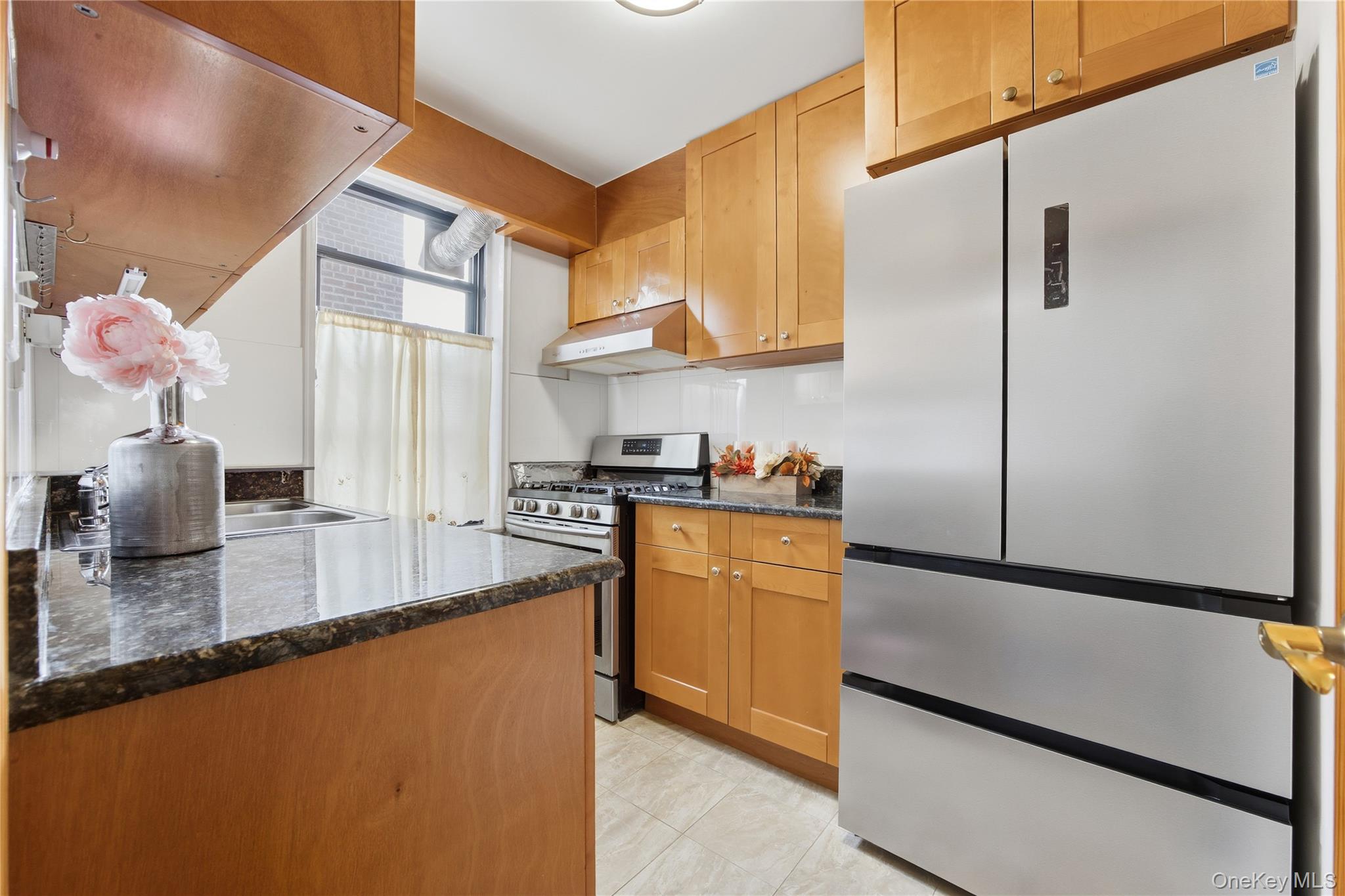 150-25 72nd Road, Unit 6A Queens, NY 11367 - Photo 6 of 13 a kitchen with stainless steel appliances granite countertop a sink a stove and a refrigerator