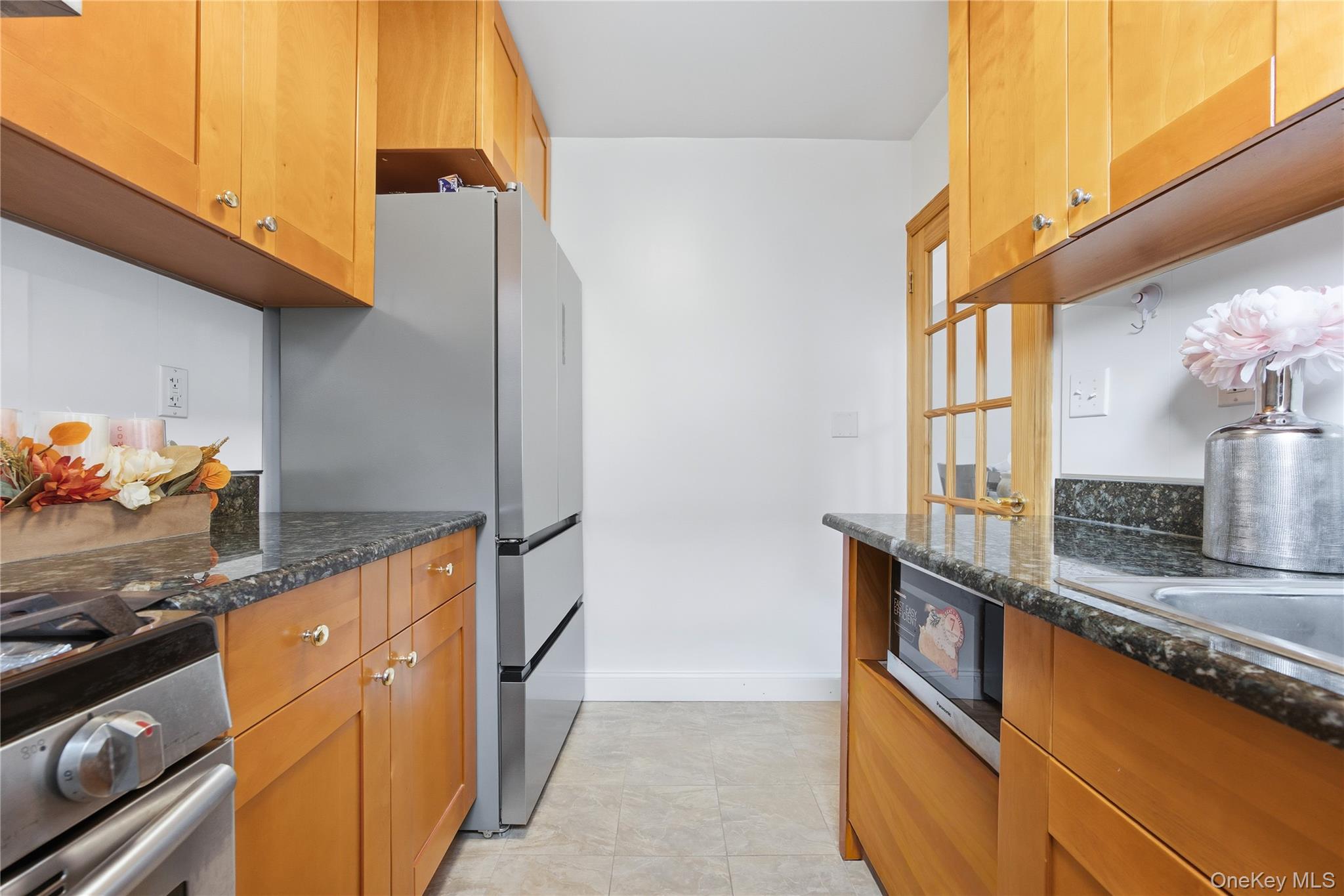 150-25 72nd Road, Unit 6A Queens, NY 11367 - Photo 7 of 13 a kitchen with stainless steel appliances granite countertop a sink and a refrigerator