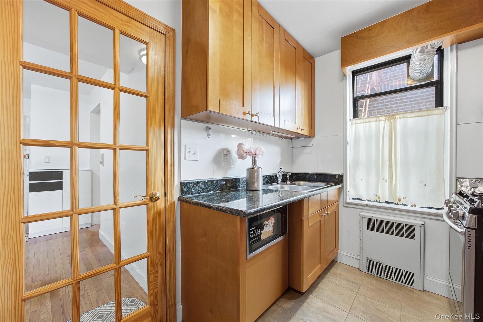 150-25 72nd Road, Unit 6A Queens, NY 11367 - Photo 8 of 13 a kitchen with stainless steel appliances granite countertop a stove and a sink