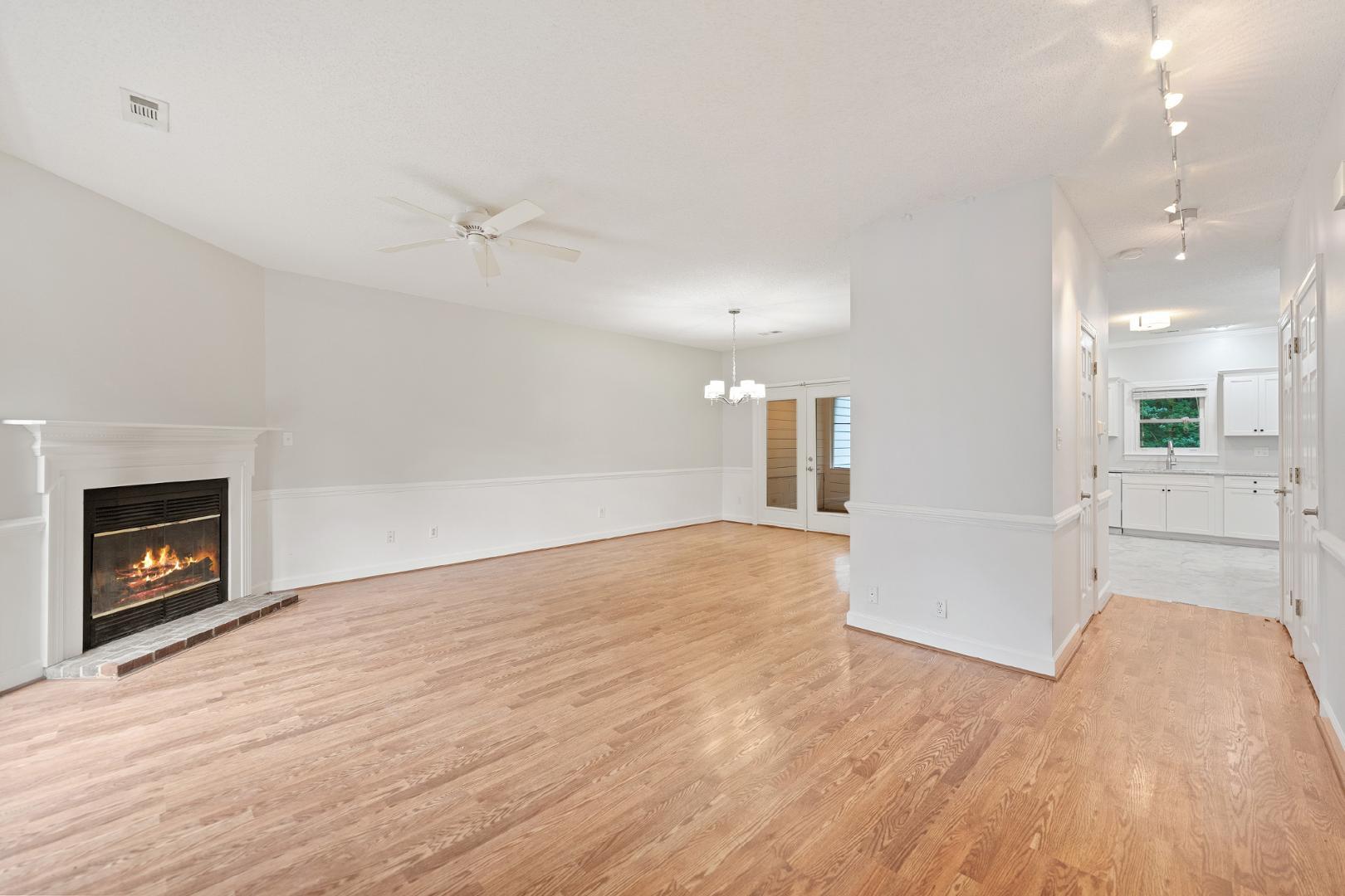 4111 Settlement Drive Durham, NC 27713 - Photo 2 of 16 an empty room with wooden floor fireplace and windows