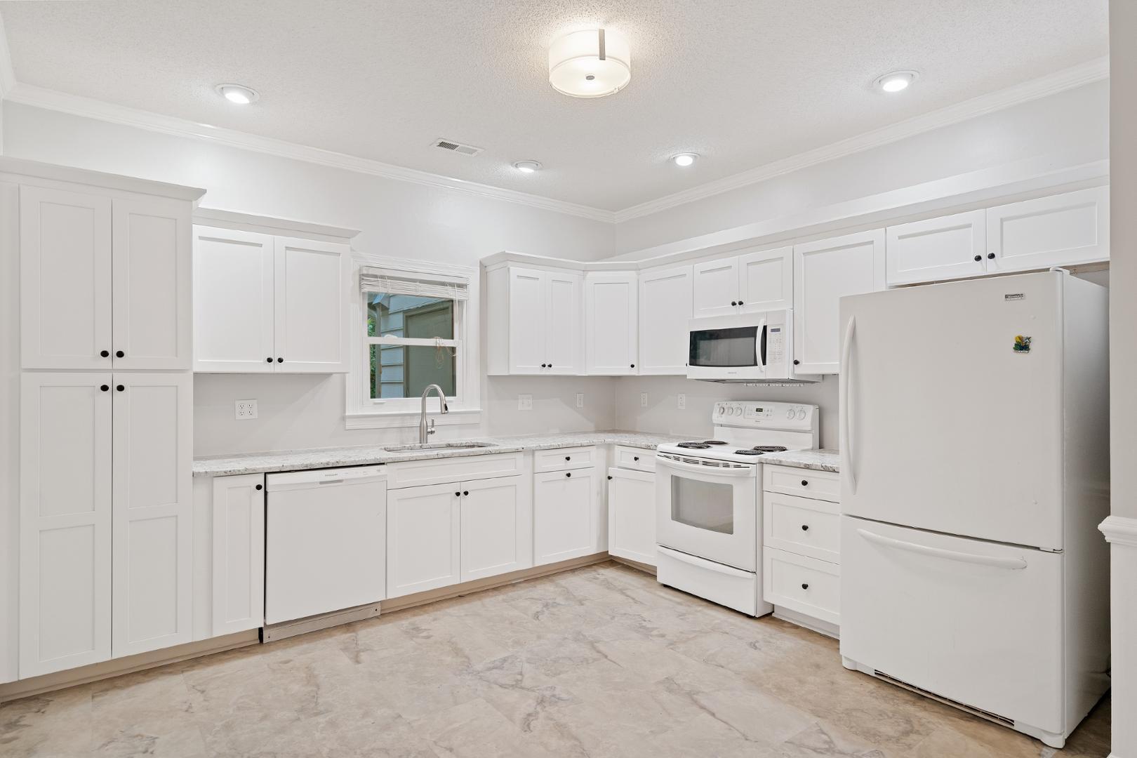 4111 Settlement Drive Durham, NC 27713 - Photo 4 of 16 a kitchen with white cabinets and white appliances
